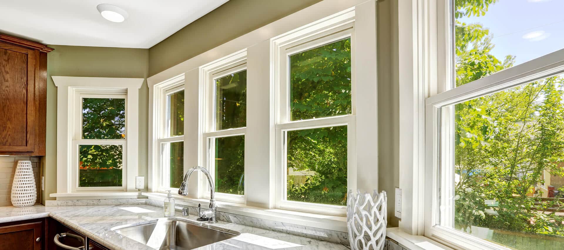 A series of double hung windows in a bright kitchen.