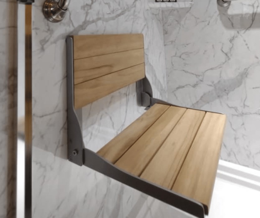 Wooden shower seat in a marble acrylic shower.