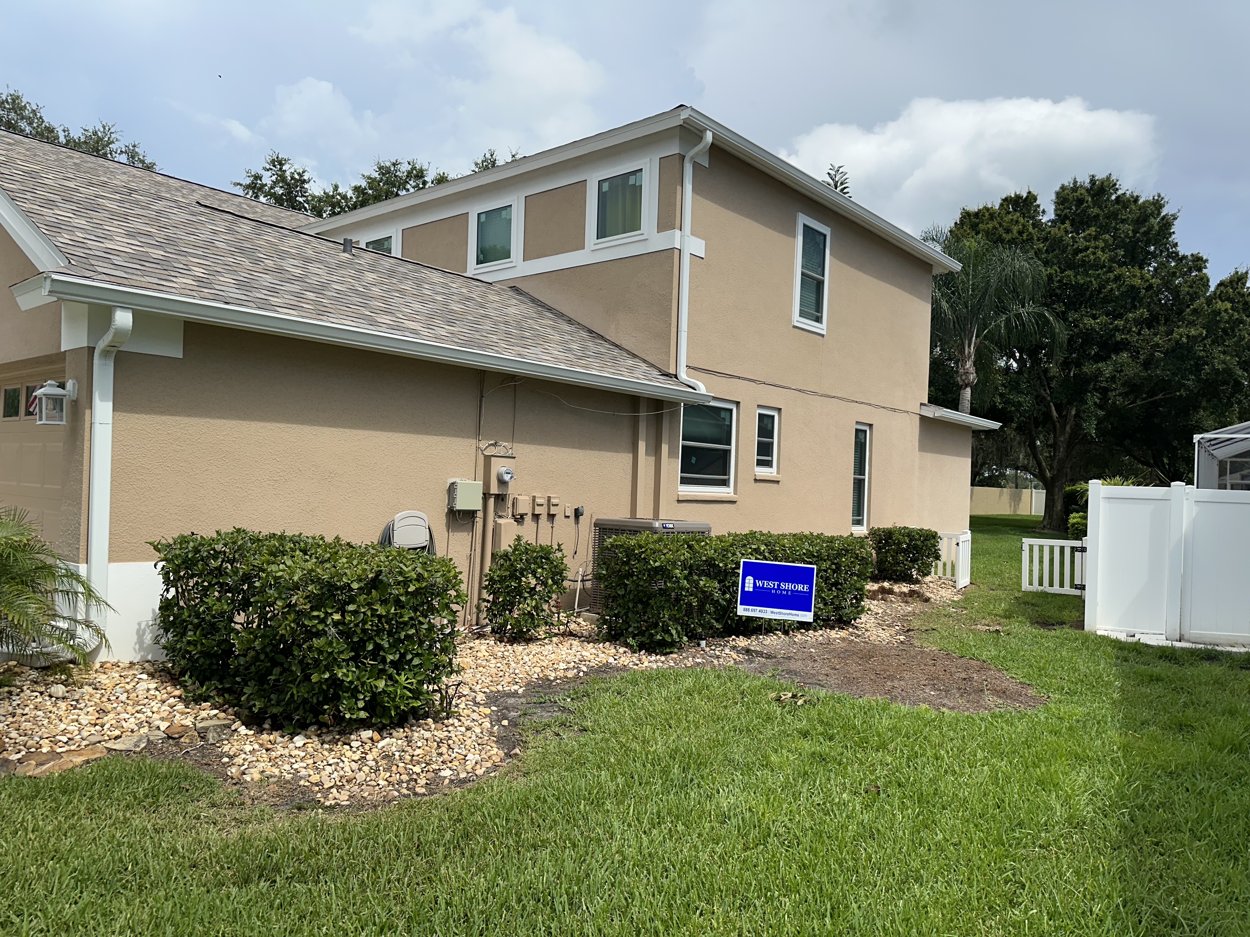 Side of a Florida home with new white windows.