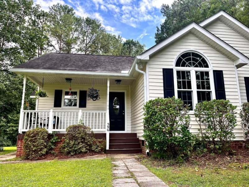 A white and black house with a new black door and new windows.