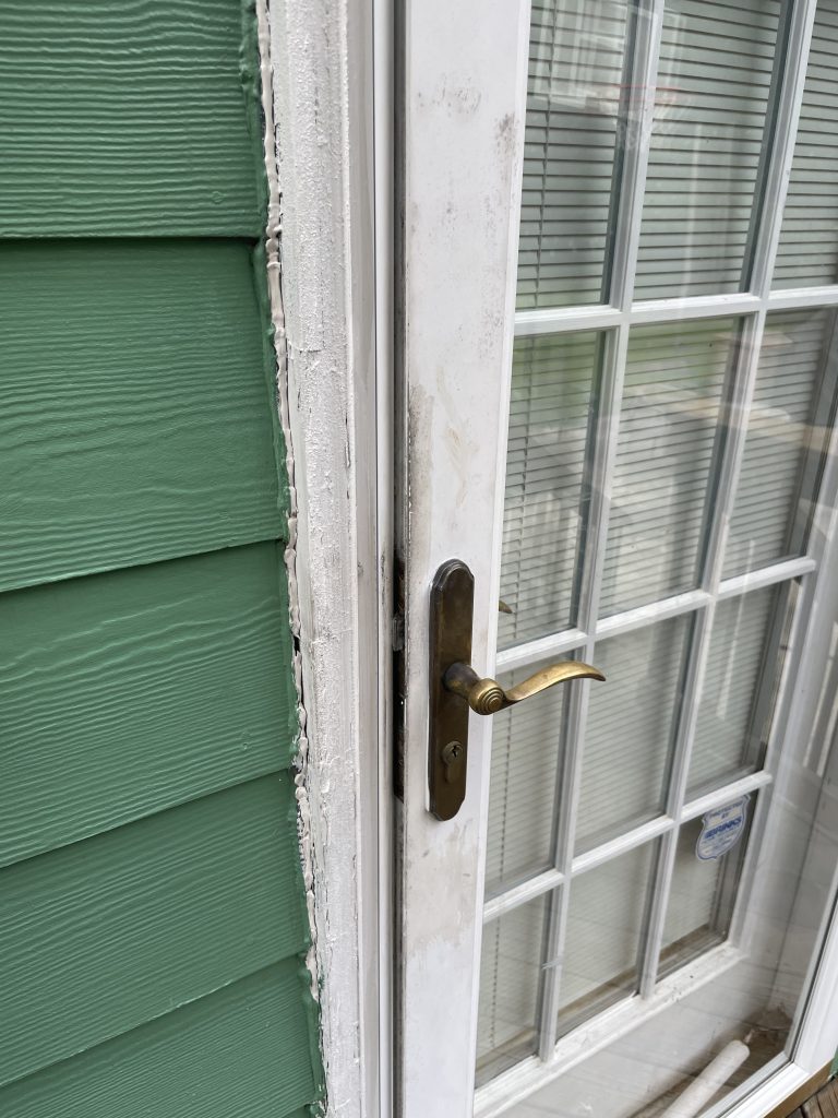 A close up of a white door handle in need of replacing.