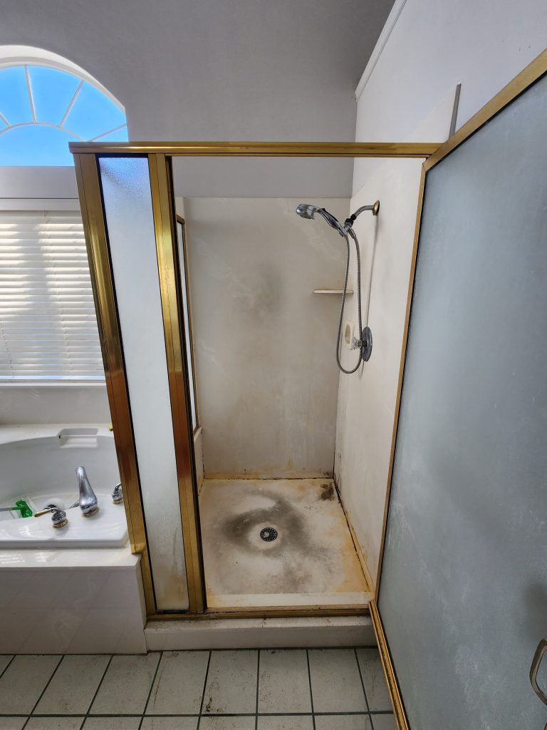 A mold-ridden and outdated walk in shower.