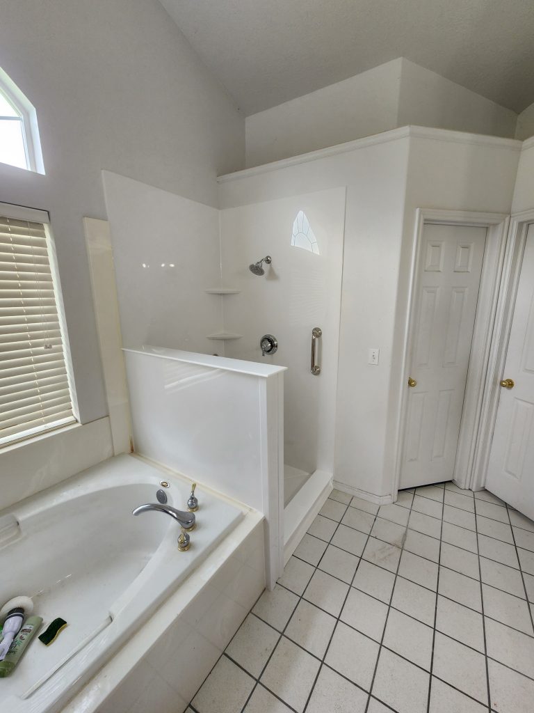 A white shower and bath showcasing a pony wall.