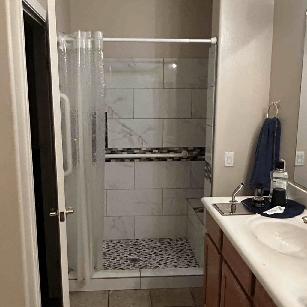 An outdated tile walk in shower with plastic curtain rod and clear plastic shower curtains. 