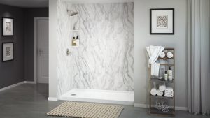 A granite acrylic walk in shower with chrome fixtures.