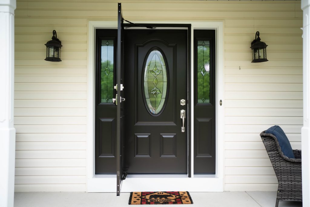 Black steel door with storm door, decorative window, and sidelites.