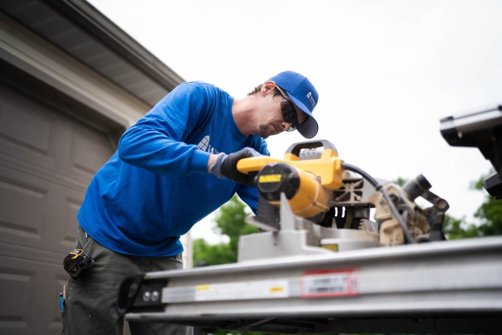 A West Shore Home installer using a power tool customizing a front door.