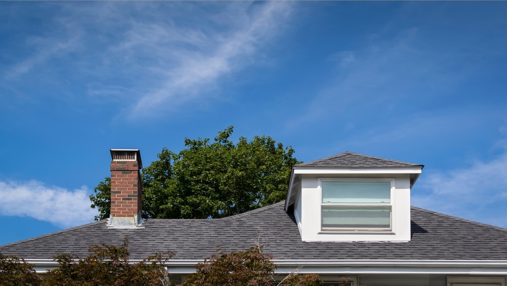 Hip,Dormer,And,Brick,Chimney,On,The,Sloped,Shingle,Roof